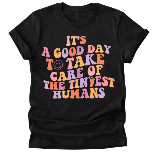 Black t-shirt with colorful text and graphics on a white background